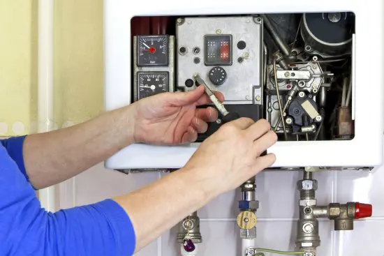 Technician repairs a scaled boiler to improve efficiency.