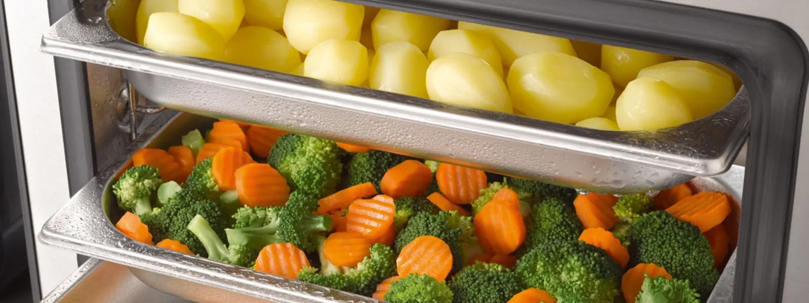 Open steam oven filled with perfectly steamed vegetables, free of limescale.