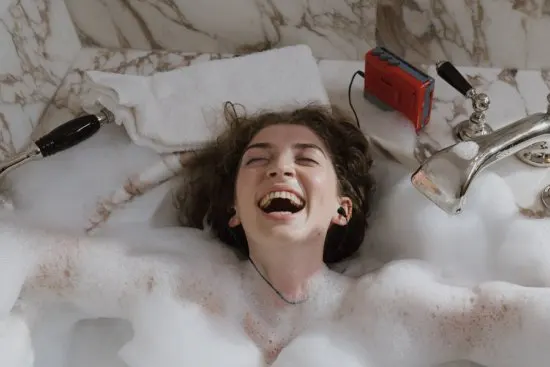 Woman relaxing in a bath surrounded by luxurious marble.